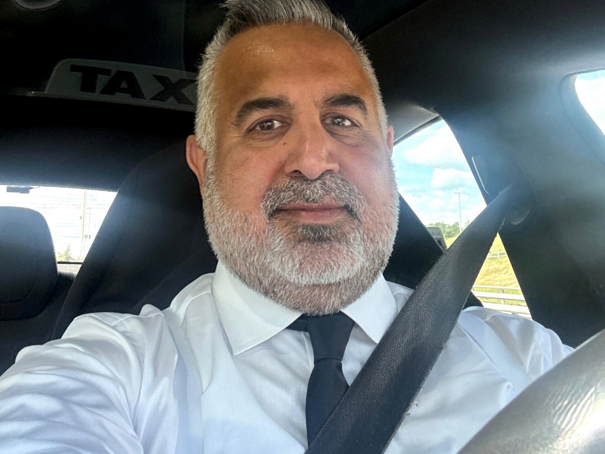 En taxibil på en våt gata i skymningen